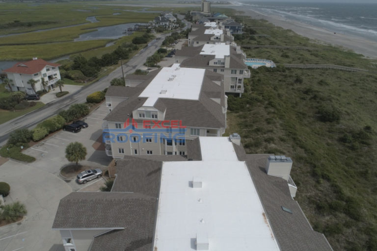 Aerial view of luxury condos in Wrightsville Beach, NC, with new shingle and TPO roofs installed.