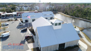 Aerial view of a metal roof installed by Excel Roofing over a shopping center in Wilmington, NC, highlighting durability and modern design.